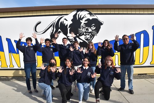 Lemoore Middle College Academic Decathlon team members raise their fingers following their Kings County AD 10th win in a row.